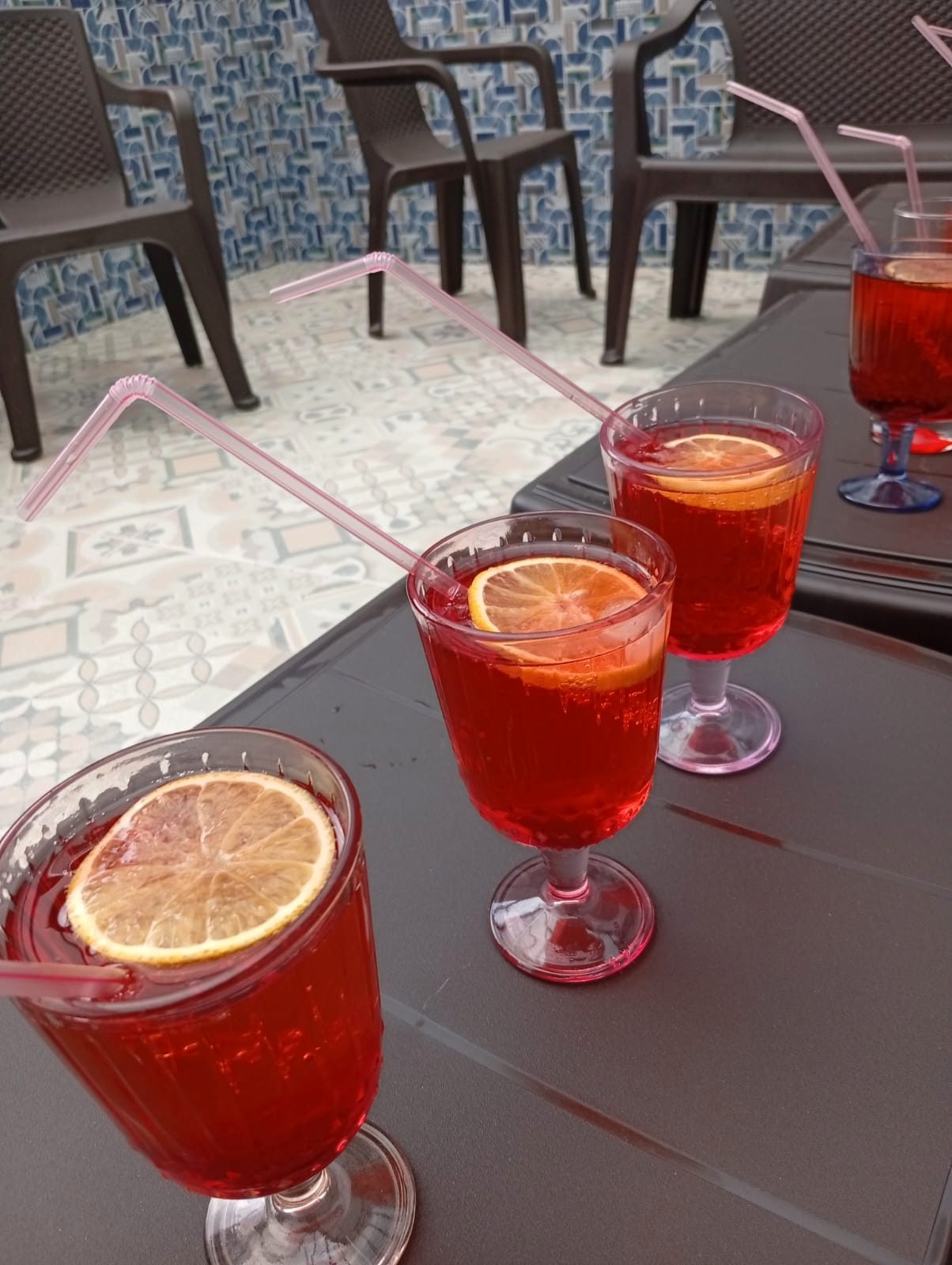 Tres copas con bebida roja y rodajas de naranja