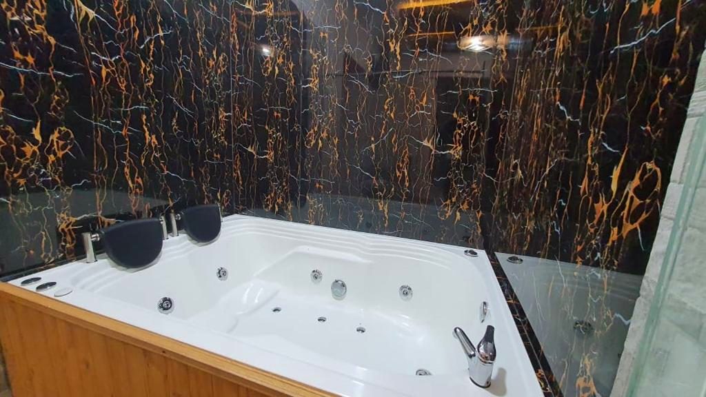 Bañera de hidromasaje con muro de mármol negro