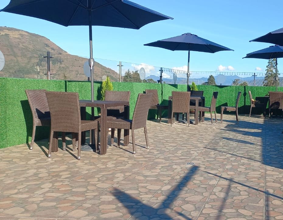 Terraza soleada con sombrillas y vista a la montaña